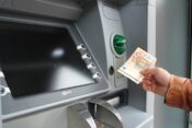 Osoba podiže novce s bankomata.