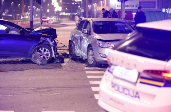 dva automobila oštećena u prometnoj nezgodi na raskrižju dvije ulice i policijsko vozilo