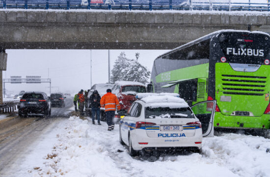 autobus, policijski auto i ljudi u snijegu na autocesti