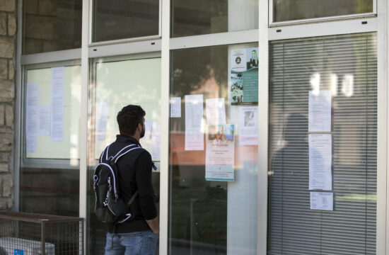 muškarac čita oglase za posao pred vratim hrvatskog zavoda za zapošljavanje